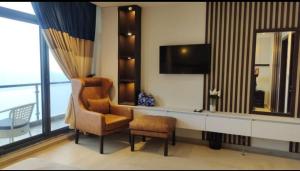 a living room with a chair and a television at Maple vista in Dargai