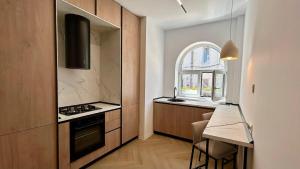a kitchen with a stove and a table and a window at Romantic central apartment in Constanţa