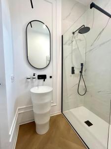 a white bathroom with a mirror and a shower at Romantic central apartment in Constanţa +17 photos