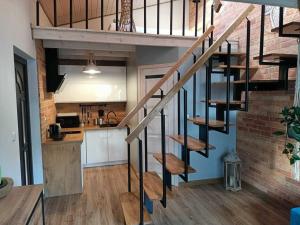 a spiral staircase in a kitchen with a brick wall at Domek Sasino in Sasino