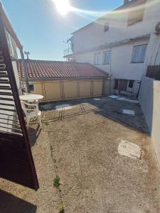 a patio with a table and a fence next to a building at Apartmani Reef House in Sutomore