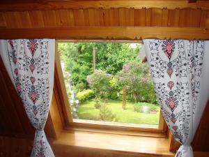 a window with curtains with a view of a garden at Kalina 2 in Zakopane