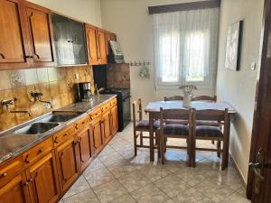 a kitchen with a sink and a table with chairs at Alex house Thassos in Skala Sotiros