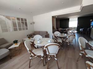 a dining room with tables and chairs and a couch at Hotel Anne De Bretagne BLOIS in Blois