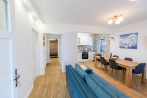 a living room with a blue couch and a table at Apartment Miranda with terrace and BBQ by the sea in Slatine