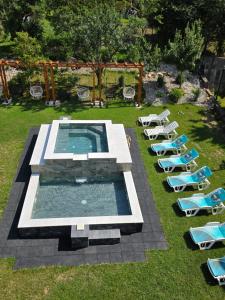 a group of lounge chairs and a swimming pool in a yard at Къща за гости Коларски in Sapareva Banya