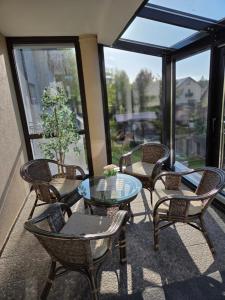 a patio with chairs and a glass table with a view at Apartamenty i pokoje Sosnowa 4 Dębki in Dębki