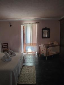 a bedroom with a bed and a window and a table at B&B Palazzo Delogu in Osidda