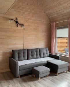 a living room with a couch and a window at Apartamenty Cztery Siostry in Zastań