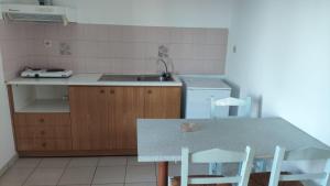 a kitchen with a sink and a table with chairs at Agnanti Kotsikia in Kotsikiá