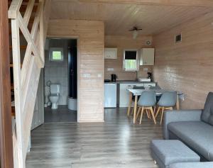a living room and kitchen with a table and chairs at Apartamenty Cztery Siostry in Zastań