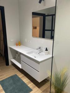 a bathroom with a white sink and a mirror at Apartament Hana in Golem +7 photos