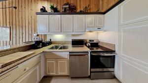 马姆莫斯湖Warm and Cozy 4 Bedroom Condo in Mammoth!的带白色橱柜和水槽的厨房 更多47张照片
