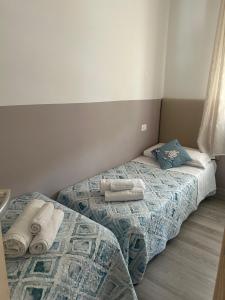 two beds in a bedroom with towels on them at Venice Queen Apartments in Cavallino-Treporti