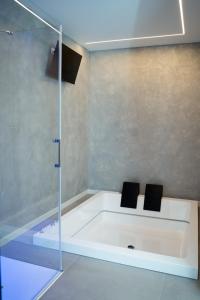 a bathroom with a tub with two black chairs at Diamond luxury house in Monopoli +10 photos