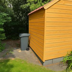 a garbage can sitting next to a yellow shed at Historische gelegen appartement more Days in Dedemsvaart