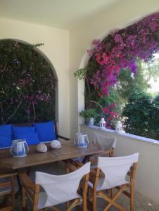 ein Esszimmer mit einem Tisch, Stühlen und Blumen in der Unterkunft Lagonissi Summer House in Lagonisi