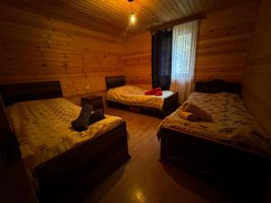 a bedroom with two beds in a log cabin at Guesthouse Luka in Ushguli