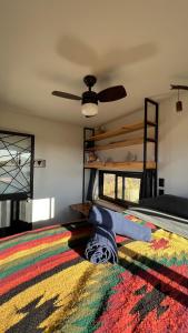 a bedroom with a bunk bed and a colorful rug at Libra Eco-Adventure Hostel in El Pescadero