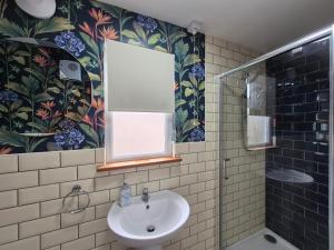 łazienka z umywalką, prysznicem i oknem w obiekcie Zoila's Rest - A self-contained studio w mieście Spalding
