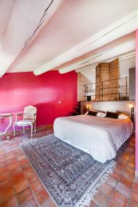 a bedroom with a large bed and a red wall at La Prévôté - Luxury Chambres d'hôtes & Gastronomic Restaurant in L'Isle-sur-la-Sorgue +29 photos