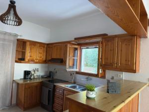 a kitchen with wooden cabinets and a sink and a window at Olive House Seaside in Rizá
