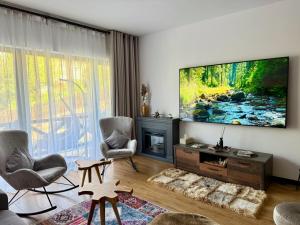 a living room with a flat screen tv on a wall at Vila Ferdinand Spa and Retreat in Sinaia