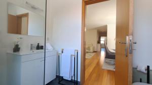 a white kitchen with a sink and a mirror at Apartamento Luar in Ribeira Brava +50 photos