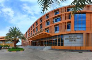 an orange building with a palm tree in front of it at Escale International Hotel in Djibouti