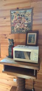 un forno a microonde appoggiato su un tavolo con un'immagine di Ecuries Leseigneur - Camping Insolites a Bolleville