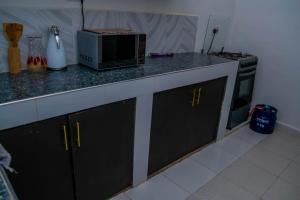 eine Küchentheke mit Mikrowelle und Herd in der Unterkunft M's BNB in Bungoma