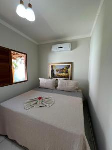 a bedroom with a bed with a bow on it at Pousada pedra da baleia in São Miguel do Gostoso