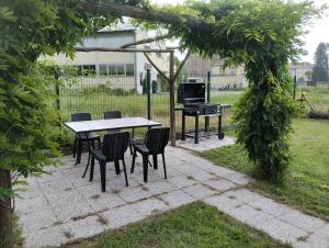 a table and chairs and a piano in a yard at Appartamento Montechiaro d'Asti in Montechiaro dʼAsti