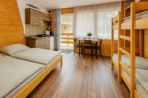 a bedroom with bunk beds and a kitchen with a table at Kemp Srdíčko in Doksy