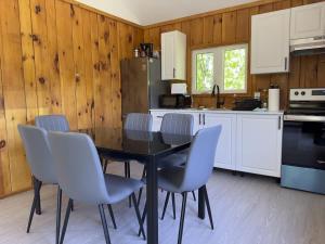 a kitchen with a black table and chairs in it at 2-Bedroom Cottage #4 - Sand Bay in Dillon