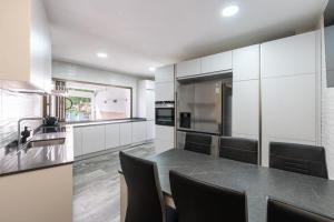 a kitchen with a large counter with chairs in it at Villa Dasil in San Pedro