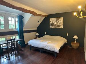 a bedroom with a bed and a table and a table and chairs at Le Moulin d'Andé in Andé +57 photos