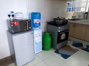 a small kitchen with a stove and a refrigerator at 1 Bedroom Apartment, Garden Estate,Nairobi in Nairobi