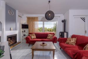 a living room with red couches and a fireplace at Villa Anna Nina in Gouves - 3BD Retreat - Sleeps 8 in Kato Gouves