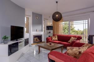 a living room with a red couch and a fireplace at Villa Anna Nina in Gouves - 3BD Retreat - Sleeps 8 in Kato Gouves