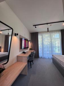 a hotel room with a desk and a mirror at Hotel Eforie Nord in Eforie Nord