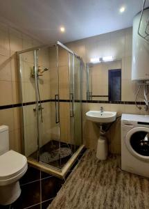 Un baño con ducha, lavabo e inodoro. en White Cliffs первая линия, en Byala