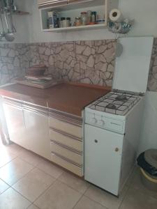 a kitchen with a stove and a counter top at Kapetanska kućica na moru in Cunski