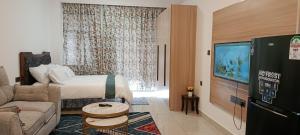 een hotelkamer met een bed, een bank en een tv bij Cozy Ruaka Retreat in Ruaka