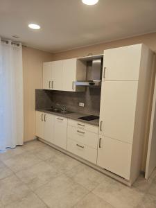 a kitchen with white cabinets and a white refrigerator at Pflege- Ferienwohnungen an der Olfe in Ahlen