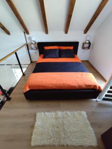 a bedroom with a bed with an orange blanket and a rug at Cottage in nature of Cetinje in Cetinje