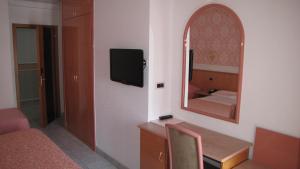 a room with a vanity and a mirror and a bed at Hotel Lanterna in Porto San Giorgio