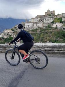 a person riding a bike down a road with a castle at Palazzo De Fabritiis in Rosciano