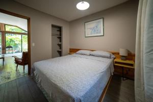 卡灵港Lake Muskoka Deluxe 2-bdrm Cottage - Pier 100 #60的一间卧室，配有一张床、一张书桌和一扇窗户 更多9张照片