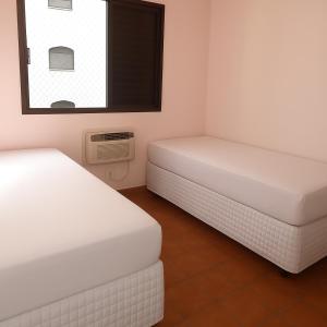 Postel nebo postele na pokoji v ubytování Pitangueiras com cadeira e guarda-sol exclusivo, limpeza diária, piscina climatizada e Wi-Fi